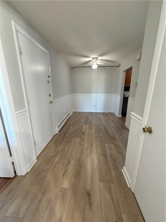 interior space featuring a baseboard heating unit and light wood-type flooring