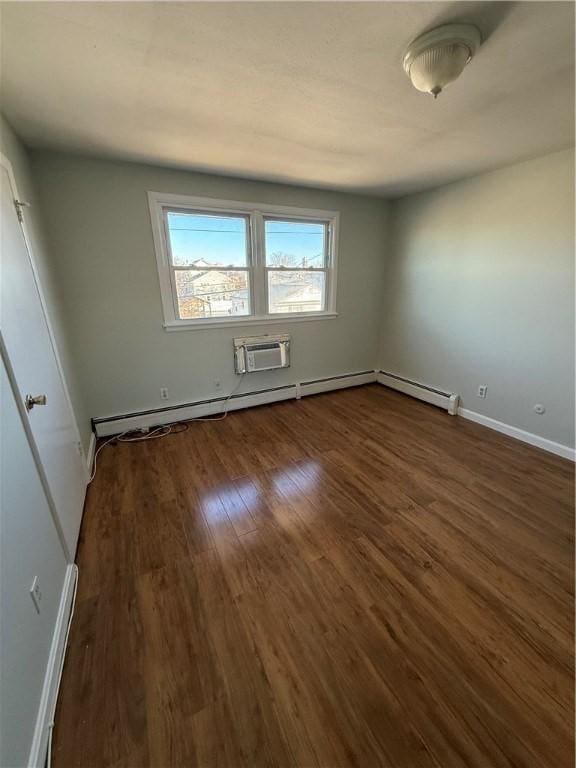 spare room with an AC wall unit and dark wood-type flooring