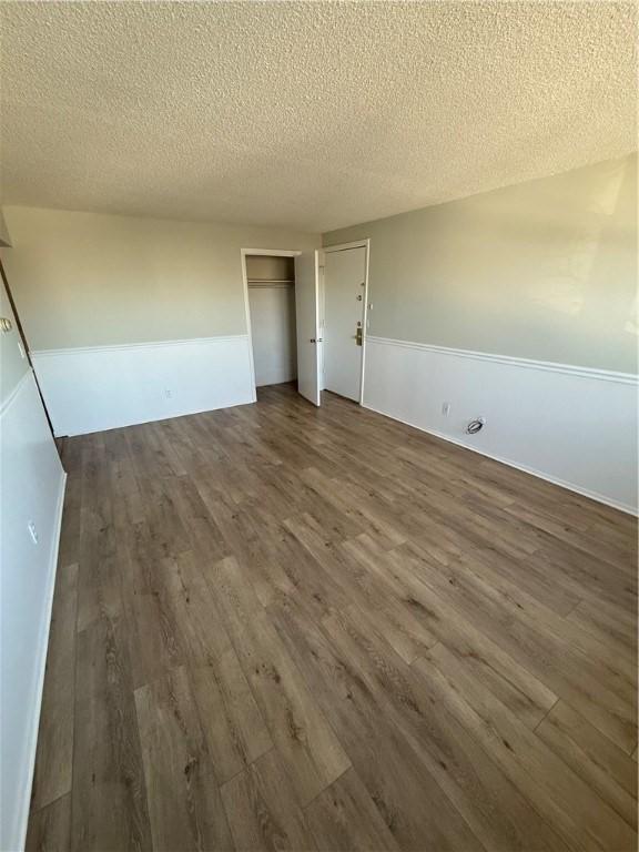 spare room featuring dark hardwood / wood-style flooring and a textured ceiling