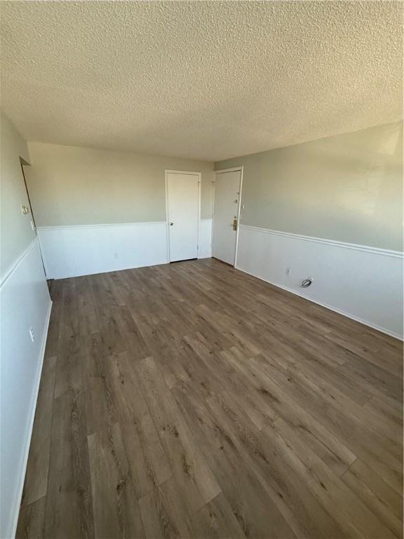 spare room with dark hardwood / wood-style flooring and a textured ceiling