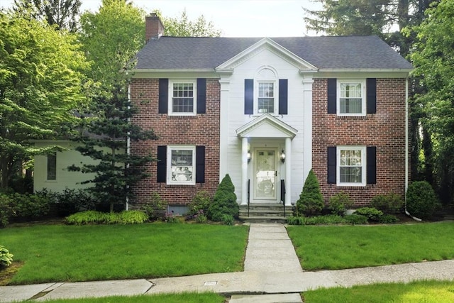 9 Dennison Rd, Worcester, MA 01609 - colonial home with brick siding, a chimney, a front yard, and a shingled roof