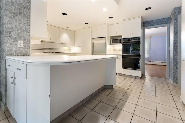 9 Dennison Rd, Worcester, MA 01609 - kitchen with appliances with stainless steel finishes, baseboard heating, light countertops, white cabinets, and a peninsula