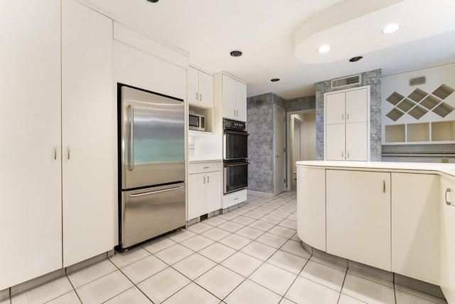 9 Dennison Rd, Worcester, MA 01609 - kitchen with built in appliances, white cabinets, light countertops, recessed lighting, and light tile patterned floors