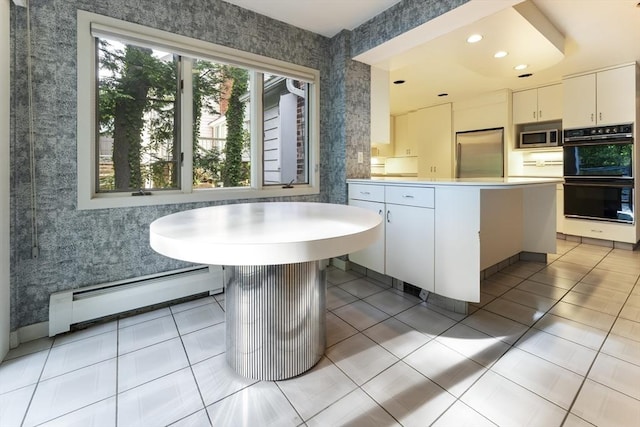 9 Dennison Rd, Worcester, MA 01609 - kitchen featuring appliances with stainless steel finishes, a baseboard radiator, wallpapered walls, a peninsula, and light countertops