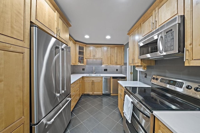 160 Pine St Unit 10, Newton, MA 02466 - kitchen featuring appliances with stainless steel finishes, dark tile patterned flooring, a sink, tasteful backsplash, and light countertops