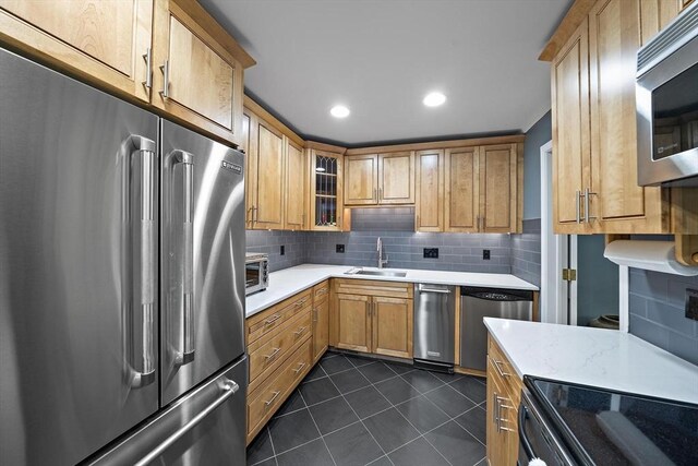 160 Pine St Unit 10, Newton, MA 02466 - kitchen featuring stainless steel appliances, a sink, light countertops, backsplash, and dark tile patterned floors