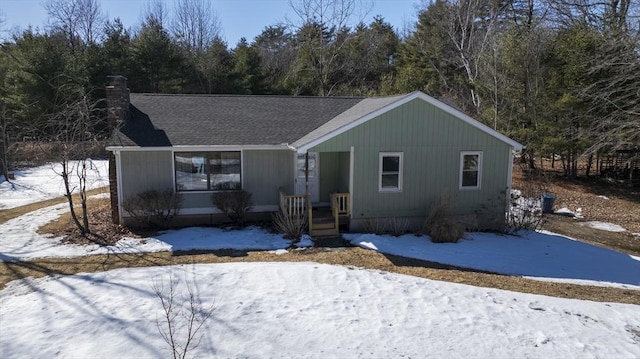 view of front of home featuring a shingled roof and a chimney