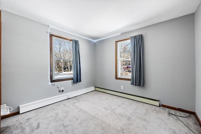 spare room featuring light carpet, a baseboard radiator, and baseboards