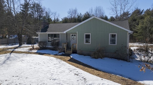 view of front of property with a shingled roof and a chimney