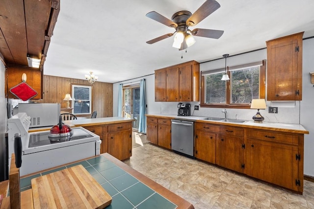 kitchen with brown cabinetry, dishwasher, white microwave, a peninsula, and a sink