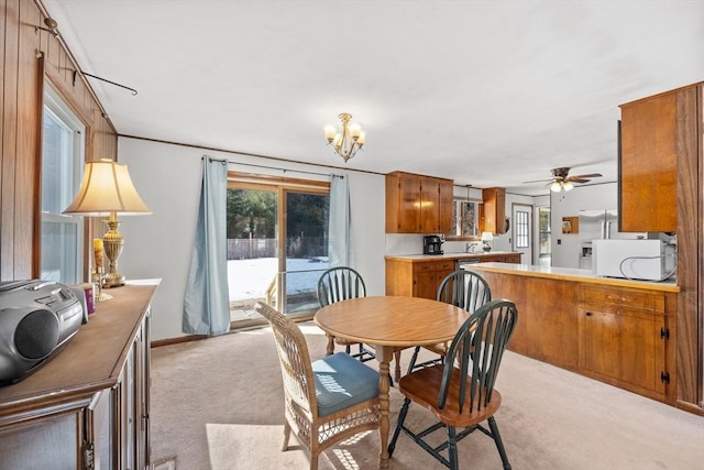 dining area with baseboards, a chandelier, and light colored carpet