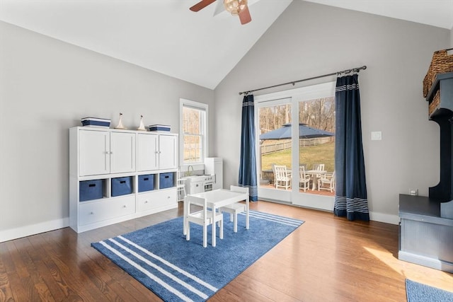 sitting room featuring ceiling fan, high vaulted ceiling, baseboards, and wood finished floors