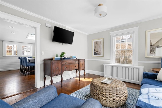 living room featuring ornamental molding, radiator, baseboards, and wood-type flooring