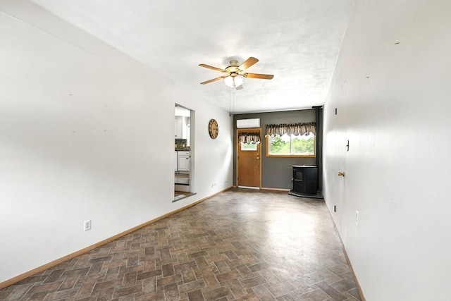 25 Saybrook Cir, South Hadley, MA 01075 - unfurnished living room with a wood stove, ceiling fan, baseboards, and a wall unit AC