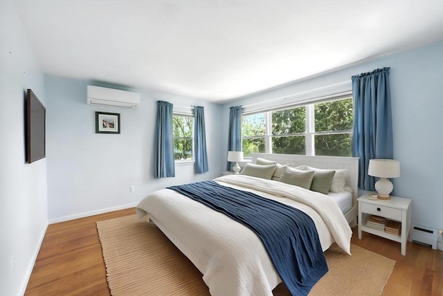 25 Saybrook Cir, South Hadley, MA 01075 - bedroom featuring a wall unit AC, wood finished floors, a baseboard heating unit, and baseboards