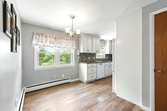 25 Saybrook Cir, South Hadley, MA 01075 - kitchen with dishwasher, a chandelier, dark countertops, light wood finished floors, and tasteful backsplash