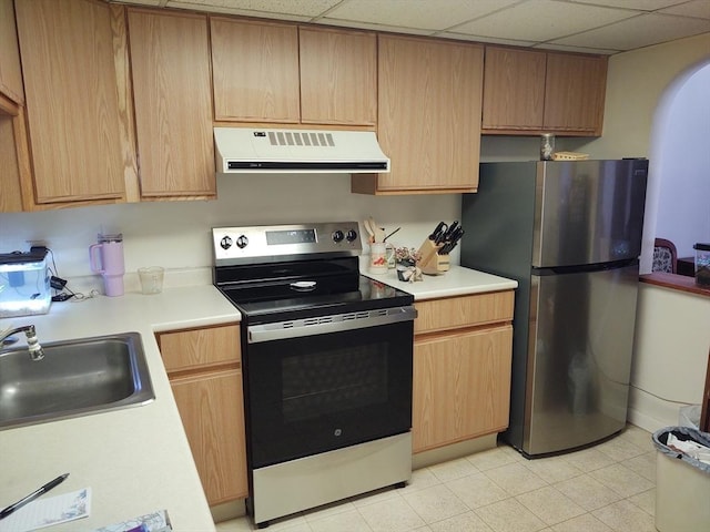 kitchen featuring extractor fan, a drop ceiling, stainless steel appliances, a sink, and light countertops