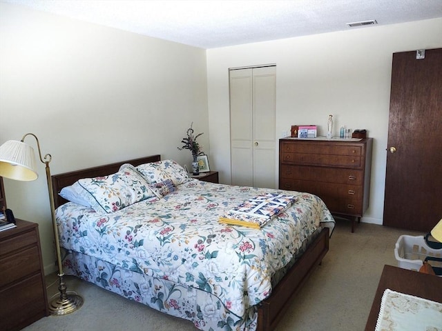 carpeted bedroom featuring a closet and visible vents