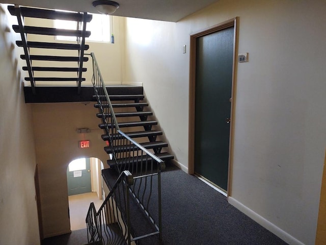 staircase featuring carpet and baseboards