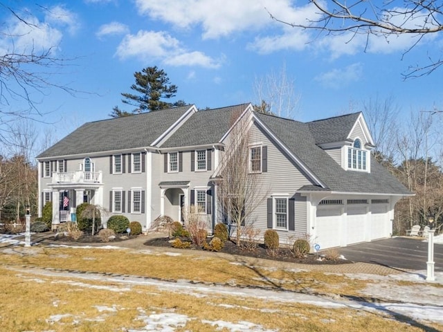 view of front of house with driveway and a balcony