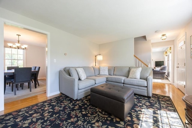 67 Jacap Dr, North Attleboro, MA 02760 - living room with a chandelier, light wood finished floors, stairs, and baseboards
