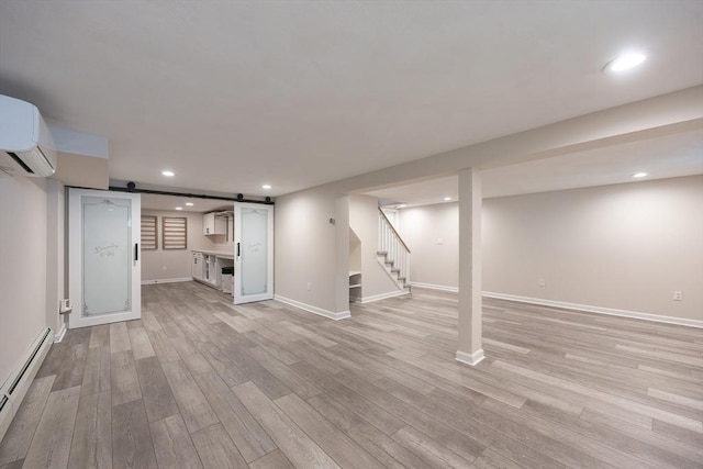 67 Jacap Dr, North Attleboro, MA 02760 - finished below grade area featuring a baseboard radiator, a barn door, a wall mounted air conditioner, light wood-type flooring, and stairs
