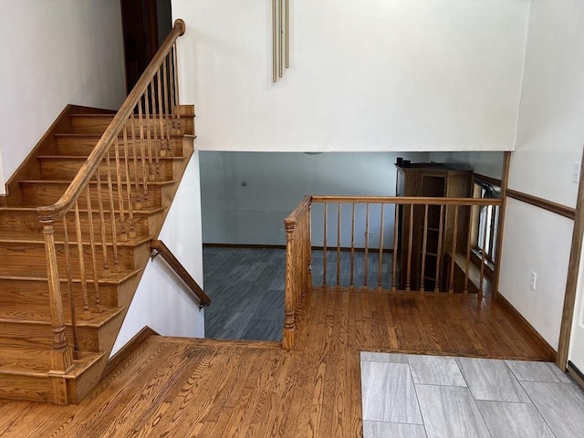 stairs with wood finished floors and baseboards