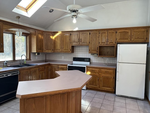 kitchen featuring light tile patterned floors, dishwasher, backsplash, freestanding refrigerator, and a sink