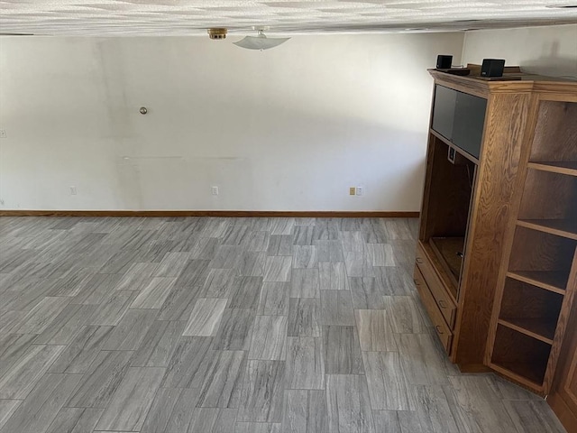 spare room featuring light wood-style flooring and baseboards