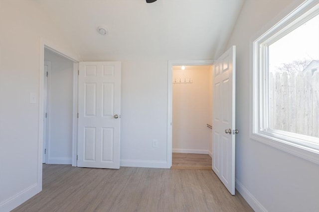 9 Bells Neck Rd Unit 4, Harwich, MA 02671 - unfurnished bedroom featuring multiple windows, light wood-style flooring, and lofted ceiling