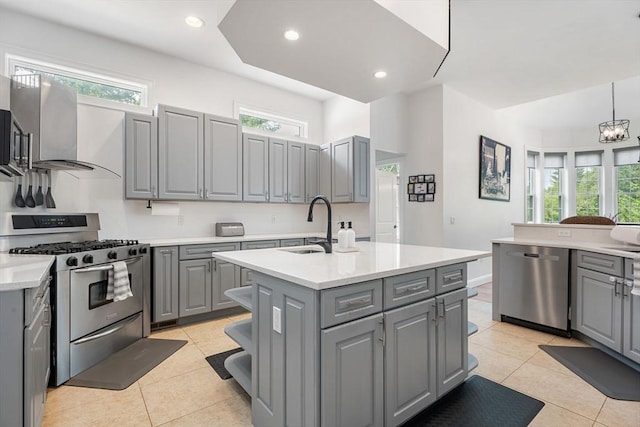 31 Cedar St, North Reading, MA 01864 - kitchen featuring gray cabinetry, appliances with stainless steel finishes, a center island with sink, light countertops, and wall chimney range hood