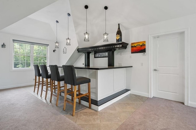 31 Cedar St, North Reading, MA 01864 - kitchen with light colored carpet, vaulted ceiling, dark countertops, pendant lighting, and white cabinetry