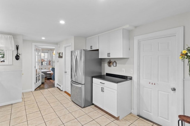 27-1/2 7th Ave, Haverhill, MA 01830 - kitchen featuring freestanding refrigerator, white cabinets, dark countertops, light tile patterned floors, and a baseboard radiator