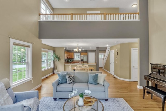 1 Chase Path Unit 1, Acton, MA 01720 - living room with a high ceiling, a chandelier, baseboards, and light wood finished floors