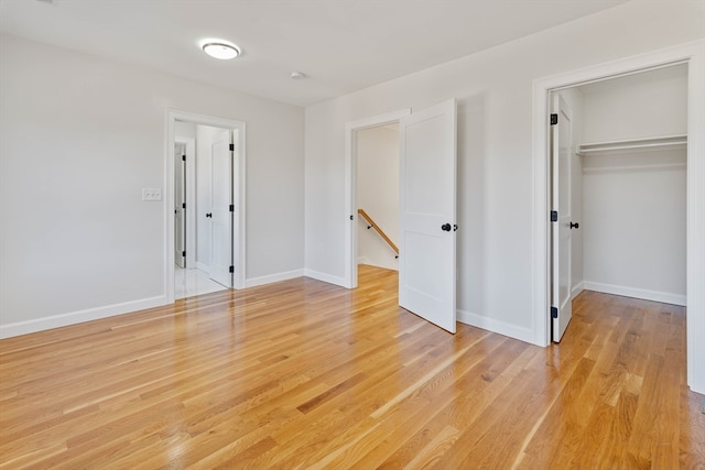 unfurnished bedroom featuring light wood-type flooring and a closet