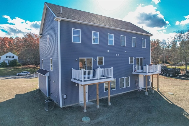 rear view of property with a balcony and a yard