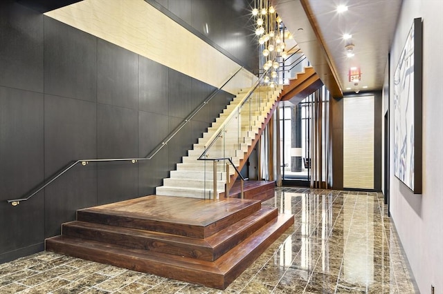 staircase with an inviting chandelier