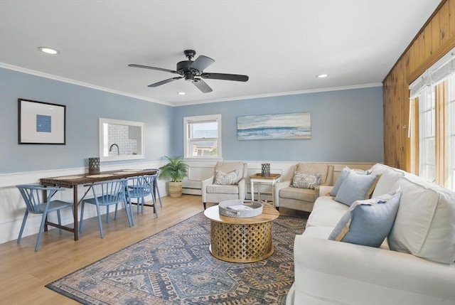 129 Northern Blvd, Newbury, MA 01951 - living area featuring a baseboard radiator, ornamental molding, light wood-style floors, a ceiling fan, and wainscoting