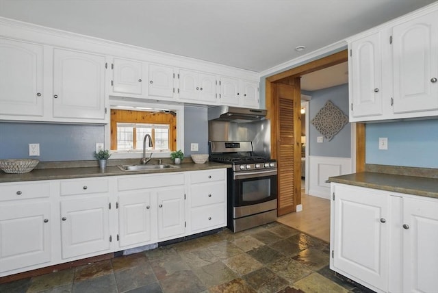 129 Northern Blvd, Newbury, MA 01951 - kitchen with stainless steel range with gas cooktop, a sink, under cabinet range hood, dark countertops, and stone tile flooring