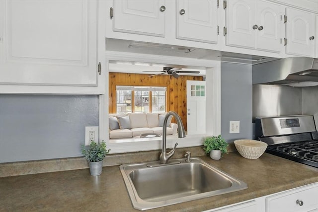 129 Northern Blvd, Newbury, MA 01951 - kitchen with gas stove, a sink, white cabinetry, ceiling fan, and wood walls