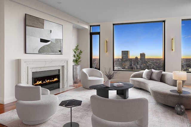 living room with expansive windows, hardwood / wood-style floors, plenty of natural light, and a premium fireplace