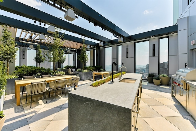 view of patio / terrace with area for grilling, a pergola, and sink