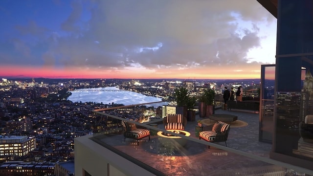 patio terrace at dusk featuring a balcony