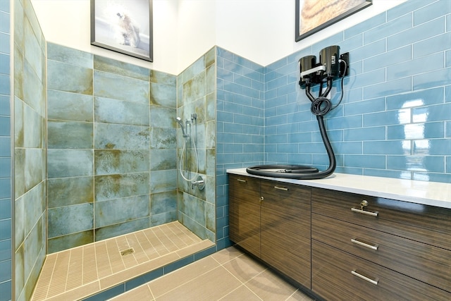 bathroom with tile walls, tiled shower, tile patterned floors, and vanity