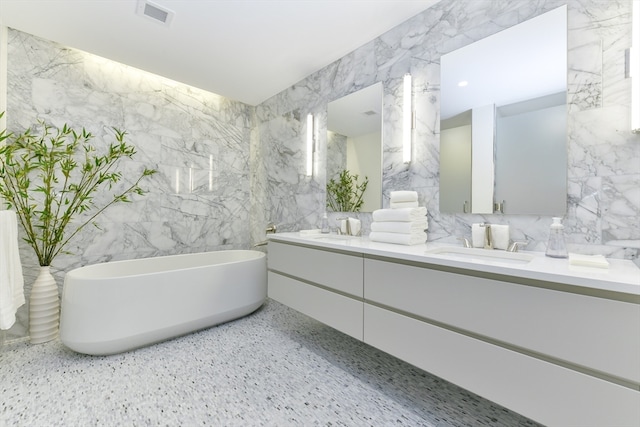 bathroom with vanity, tile walls, and a washtub