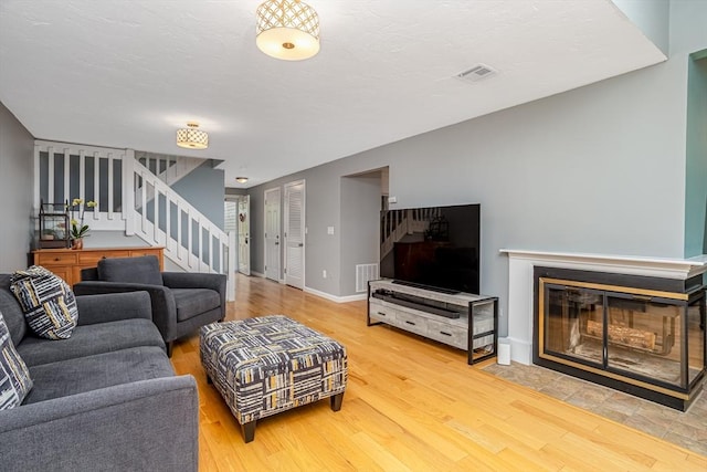 706 Ridgefield Cir Unit A, Clinton, MA 01510 - living area with stairs, wood finished floors, and a multi sided fireplace
