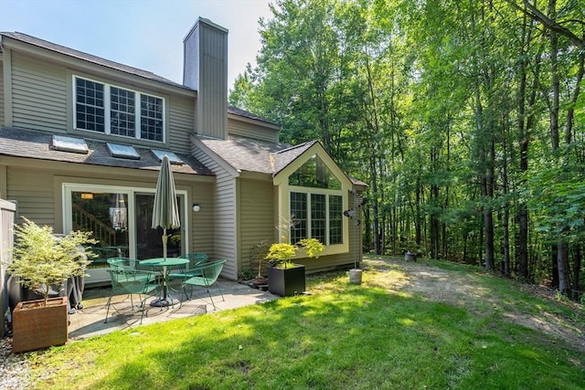 706 Ridgefield Cir Unit A, Clinton, MA 01510 - back of property featuring a patio area, a chimney, a lawn, and a shingled roof