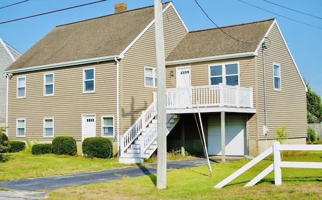 rear view of house featuring a garage and a yard