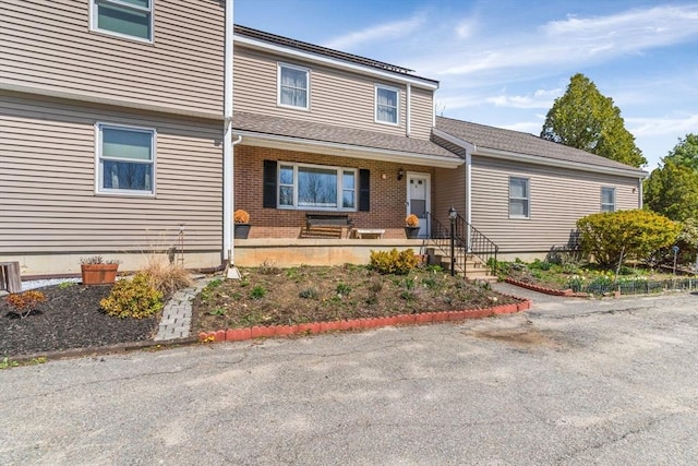 view of front of home featuring covered porch and brick siding