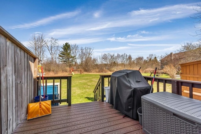 wooden terrace featuring a lawn and area for grilling